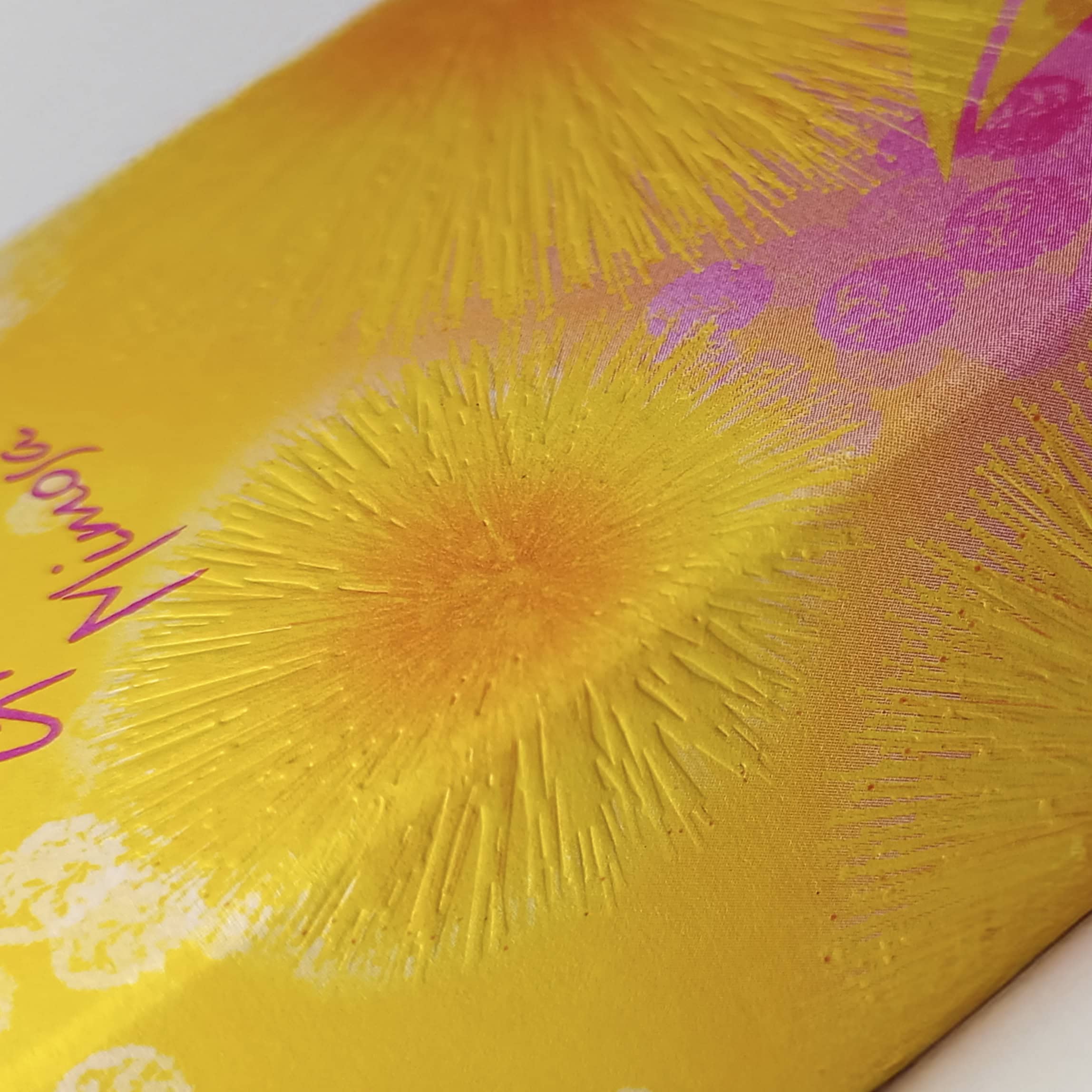 Extreme close-up showing the embossed texture and vibrant yellow finish achieved via UV offset printing by Lecagraphics