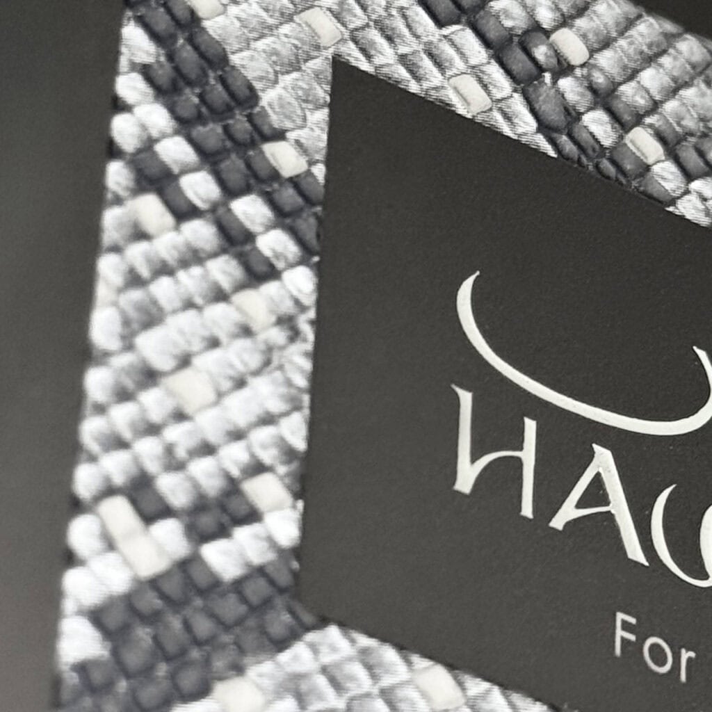 Macro shot of a snakeskin texture effect on a luxury box, showcasing high-build varnish capabilities in screen printed packaging