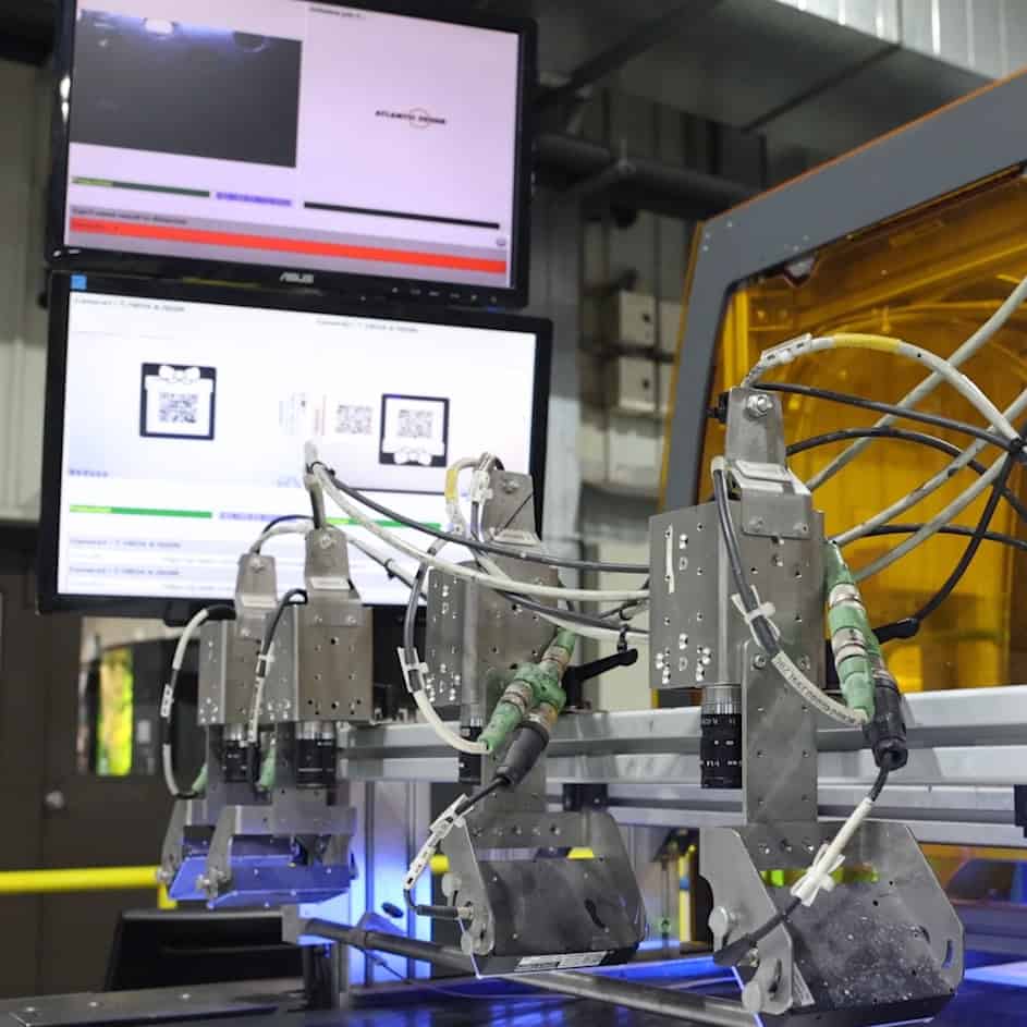 Maquinaria de inspección automatizada con monitores de control, utilizada para garantizar el cumplimiento estricto de las políticas de calidad en la línea de producción.