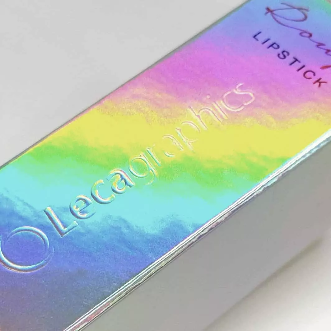 Acabado de laminados holográficos con efecto arcoíris sobre logotipo de marca en estuche de cosmética.